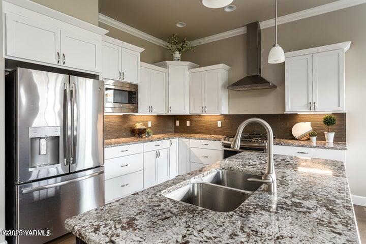 7310 Whitman Avenue Yakima, WA 98903 - Photo 11 of 31 a kitchen with stainless steel appliances granite countertop a sink refrigerator and cabinets