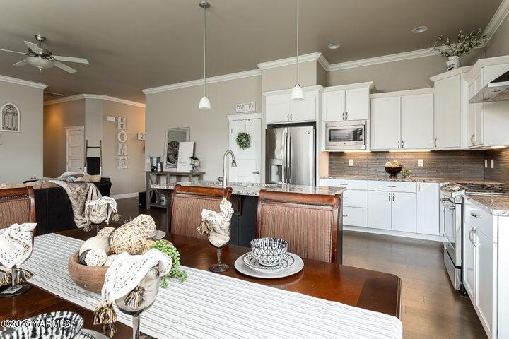 7310 Whitman Avenue Yakima, WA 98903 - Photo 15 of 31 a kitchen with stainless steel appliances kitchen island granite countertop a stove a sink a refrigerator and white cabinets