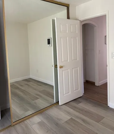 an empty room with wooden floor and entryway