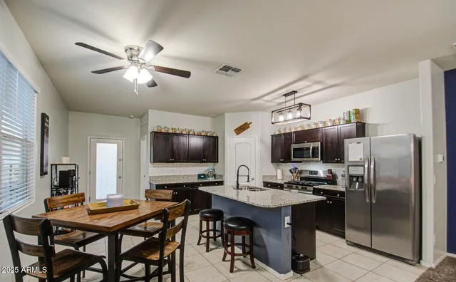 a kitchen with kitchen island a dining table and chairs