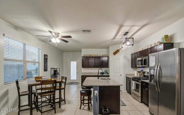 a kitchen with kitchen island granite countertop a sink appliances and cabinets