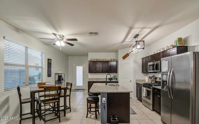 a kitchen with kitchen island granite countertop a sink appliances and cabinets