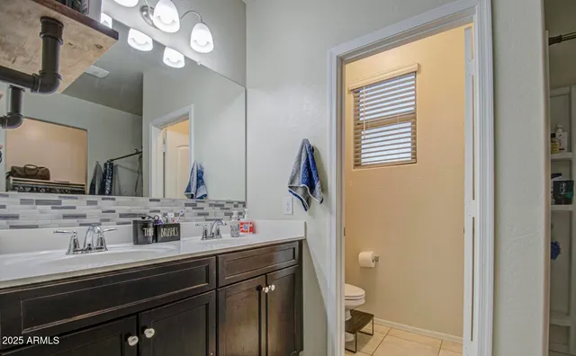 a en suite bathroom with a sink vanity granite and a mirror