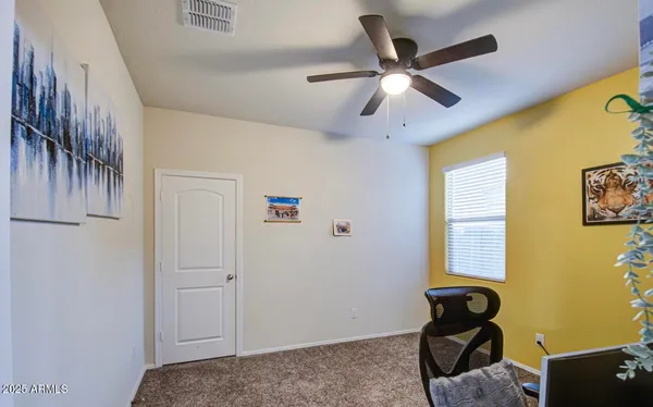 a view of a workspace with furniture and a ceiling fan