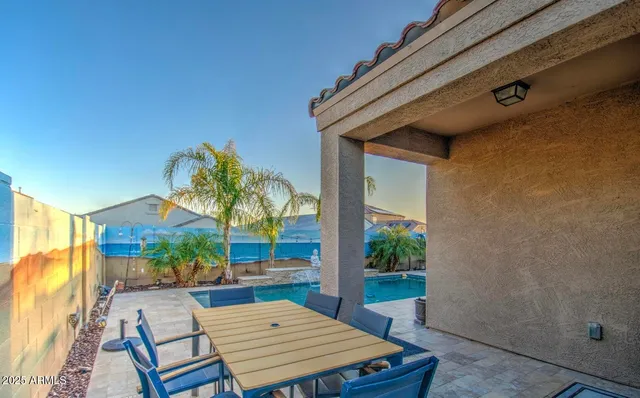 a view of a swimming pool with a lounge chair and palm trees