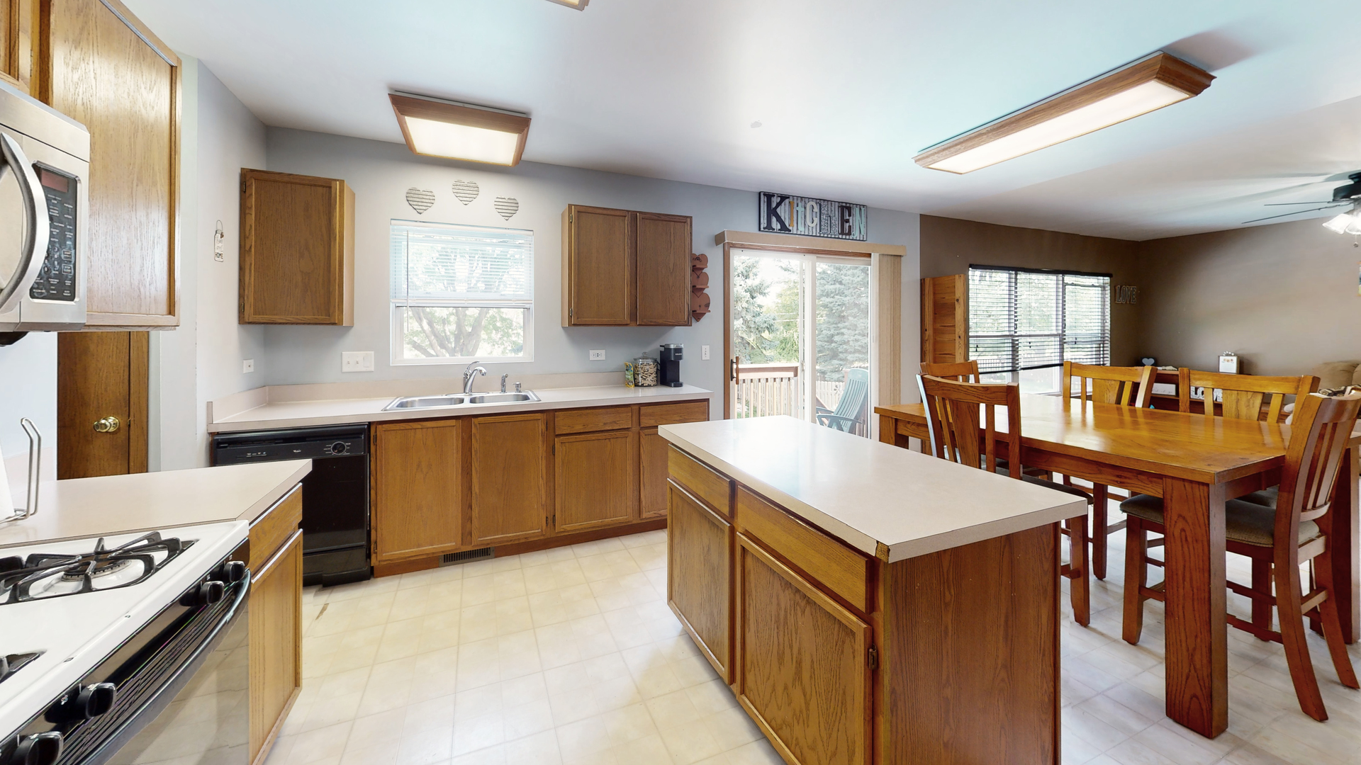 2048 Norwich Drive Bartlett, IL 60103 - Photo 6 of 25 a kitchen with a stove a sink a dining table and chairs