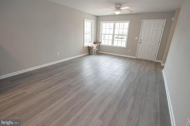 a kitchen with a refrigerator stove and wooden floor
