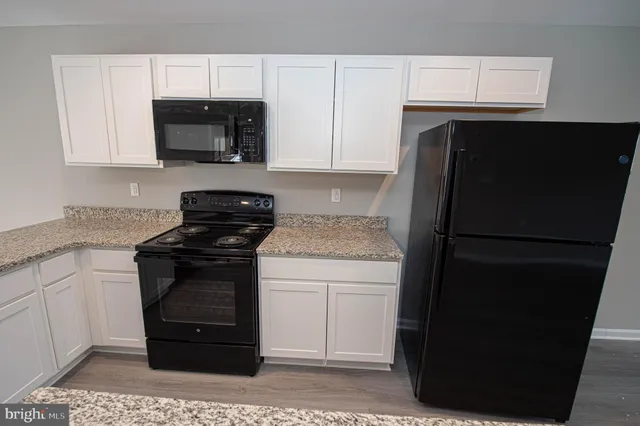 a living room with stainless steel appliances furniture and a flat screen tv