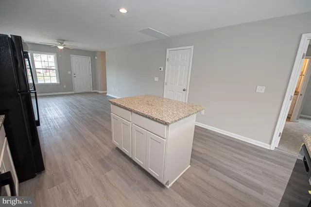 a view of a kitchen with a sink a microwave and wooden floor