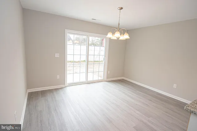 an empty room with windows and ceiling fan