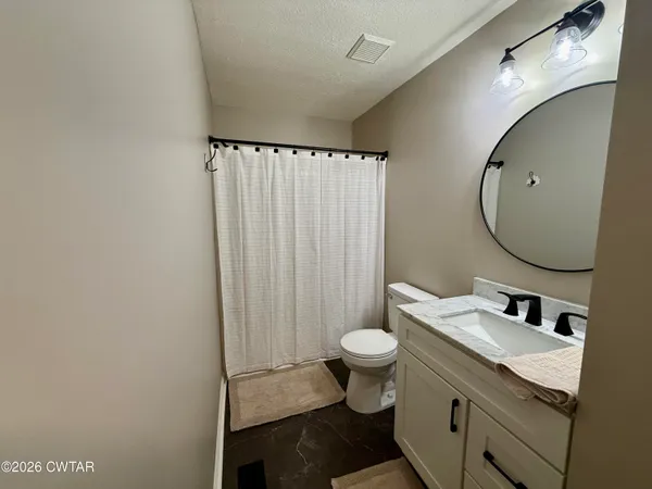 a bathroom with a sink toilet a mirror and vanity