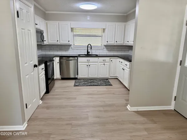 a kitchen with granite countertop white cabinets and white appliances