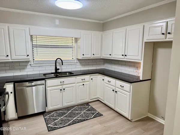 a kitchen with granite countertop white cabinets and white appliances