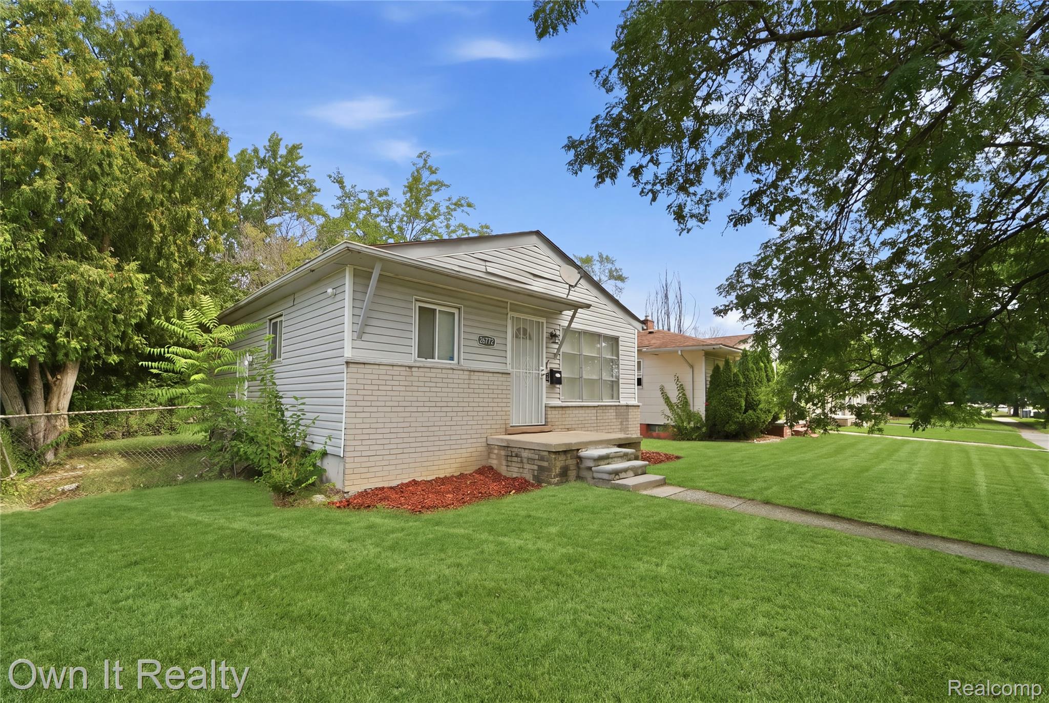 26772 Colgate Street Inkster, MI 48141 - Photo 2 of 25 Single-story residence featuring light-colored siding and brick accents, a covered entry, and a concrete walkway