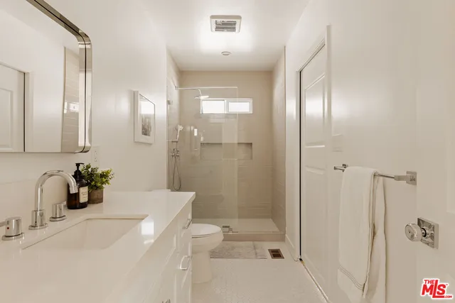 a bathroom with a sink and mirror with shower