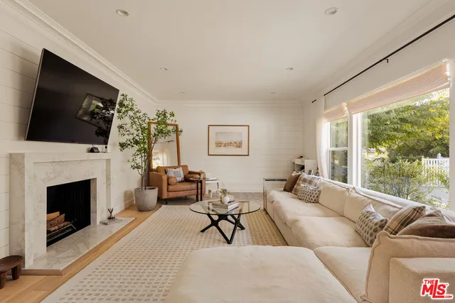 a living room with furniture a flat screen tv and a fireplace
