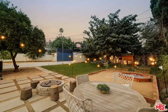 a view of backyard with table and chairs and a fire pit