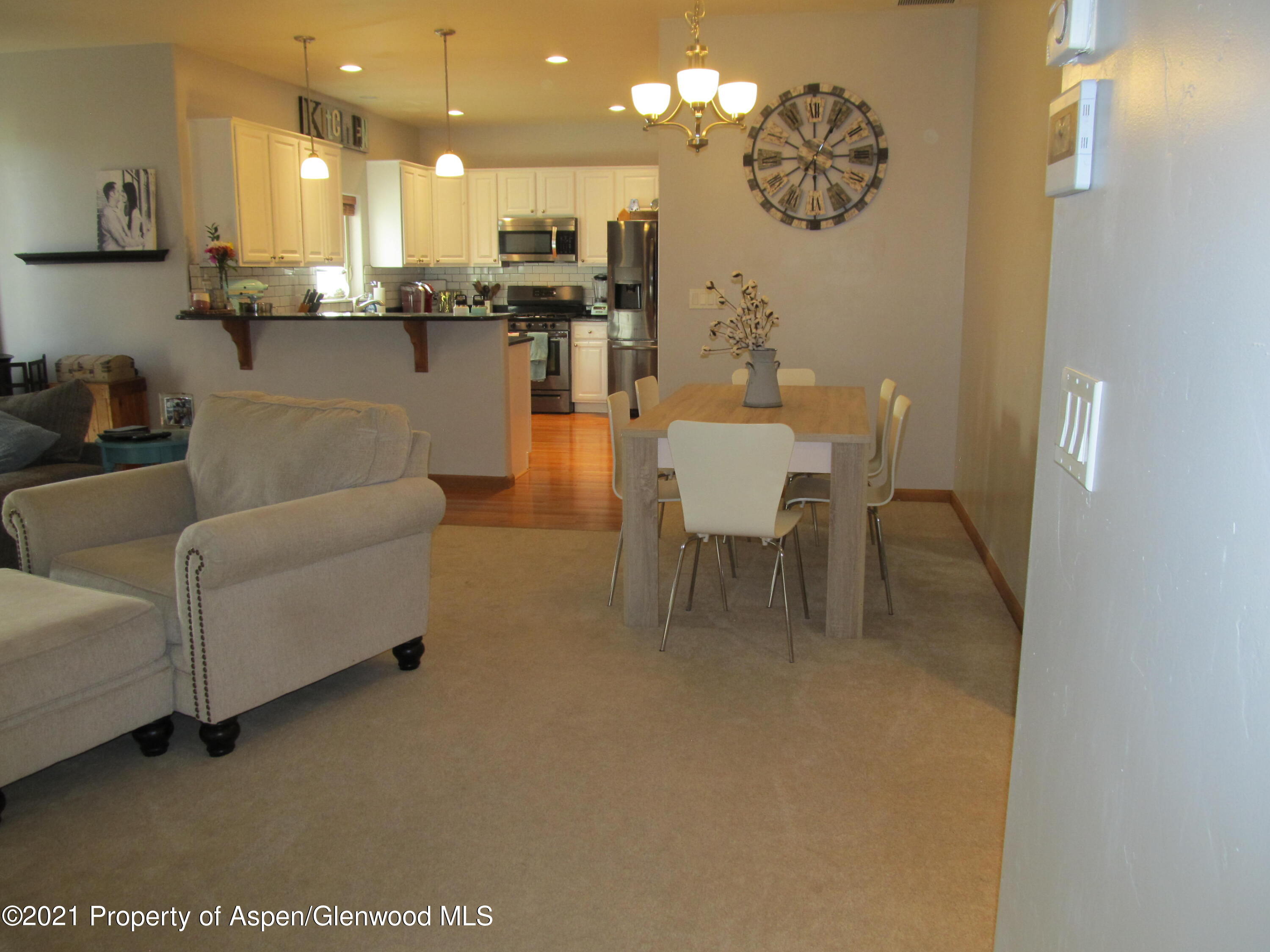 1123 East 19th Street Rifle, CO 81650 - Photo 13 of 37 a living room with couches kitchen view and a dining table view