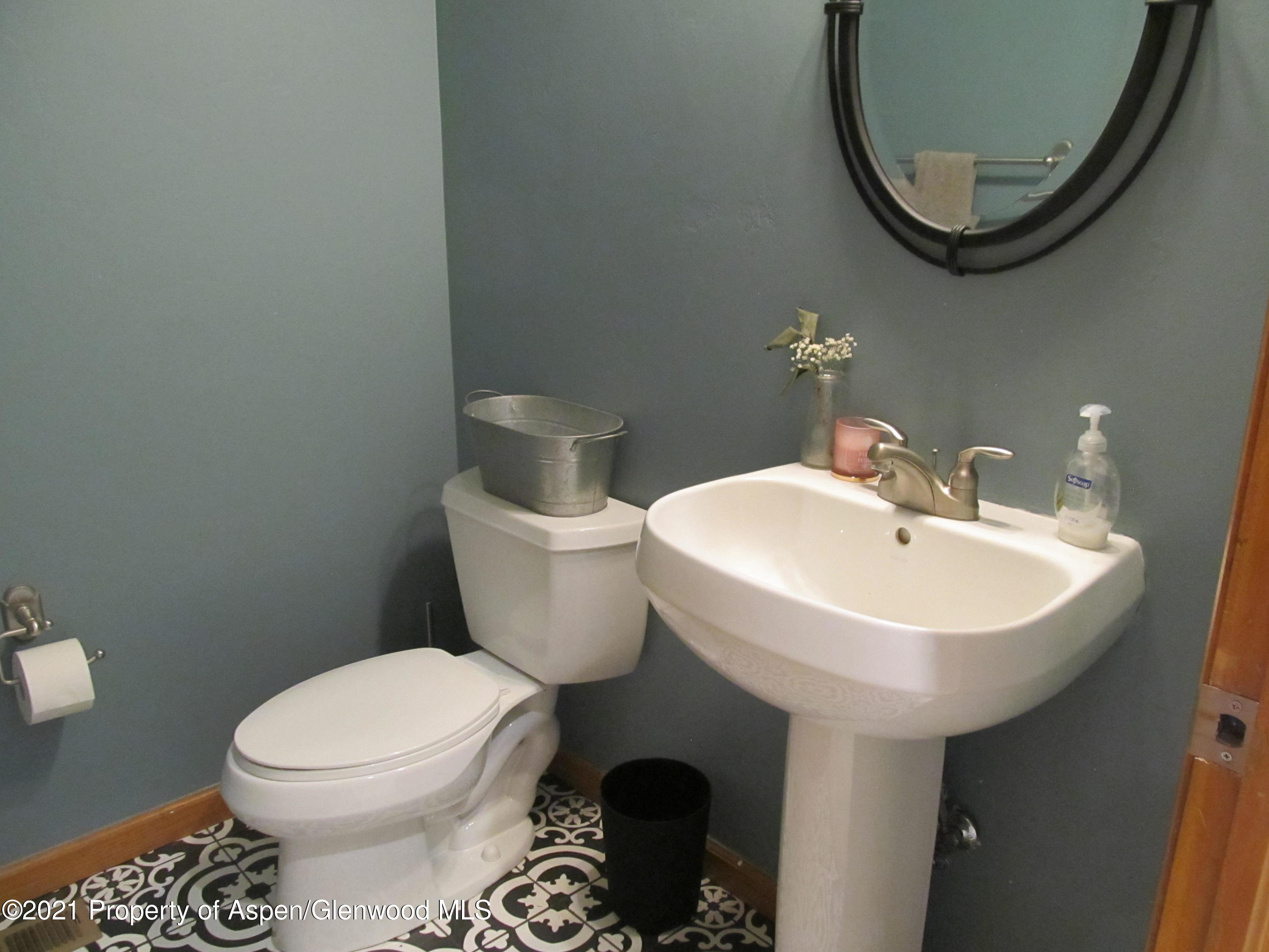 1123 East 19th Street Rifle, CO 81650 - Photo 16 of 37 a bathroom with a sink a mirror and a toilet