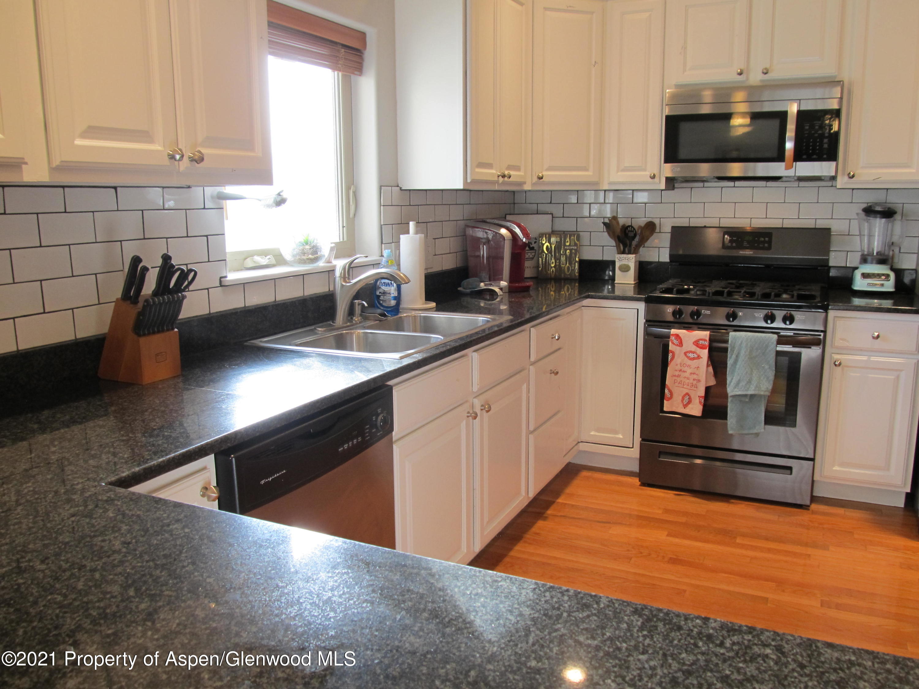 1123 East 19th Street Rifle, CO 81650 - Photo 8 of 37 a kitchen with stainless steel appliances granite countertop a stove a sink and a microwave