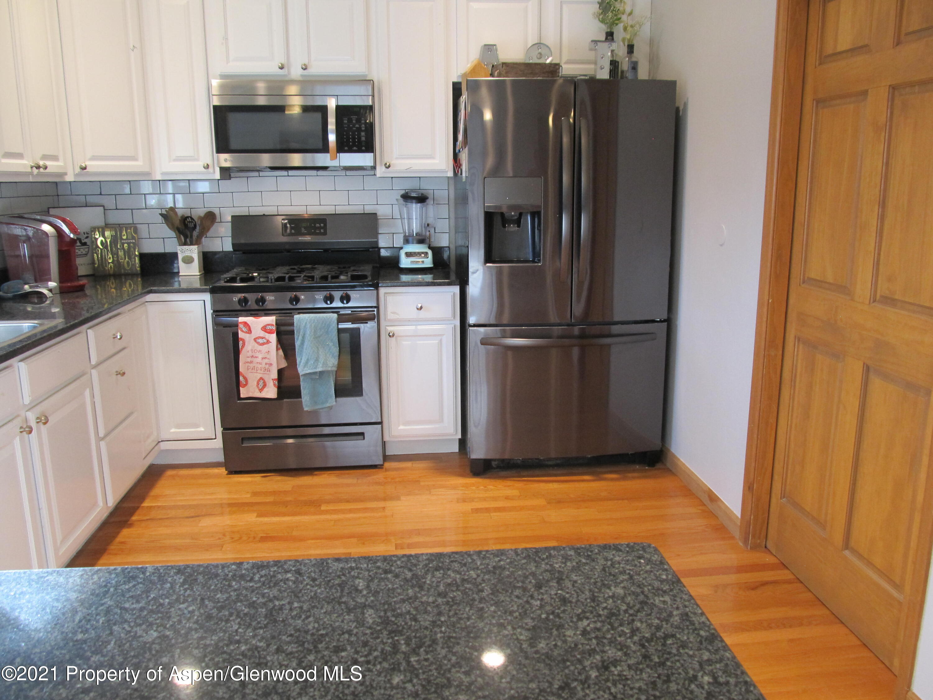 1123 East 19th Street Rifle, CO 81650 - Photo 9 of 37 a kitchen with stainless steel appliances granite countertop a refrigerator a stove top oven a sink and dishwasher