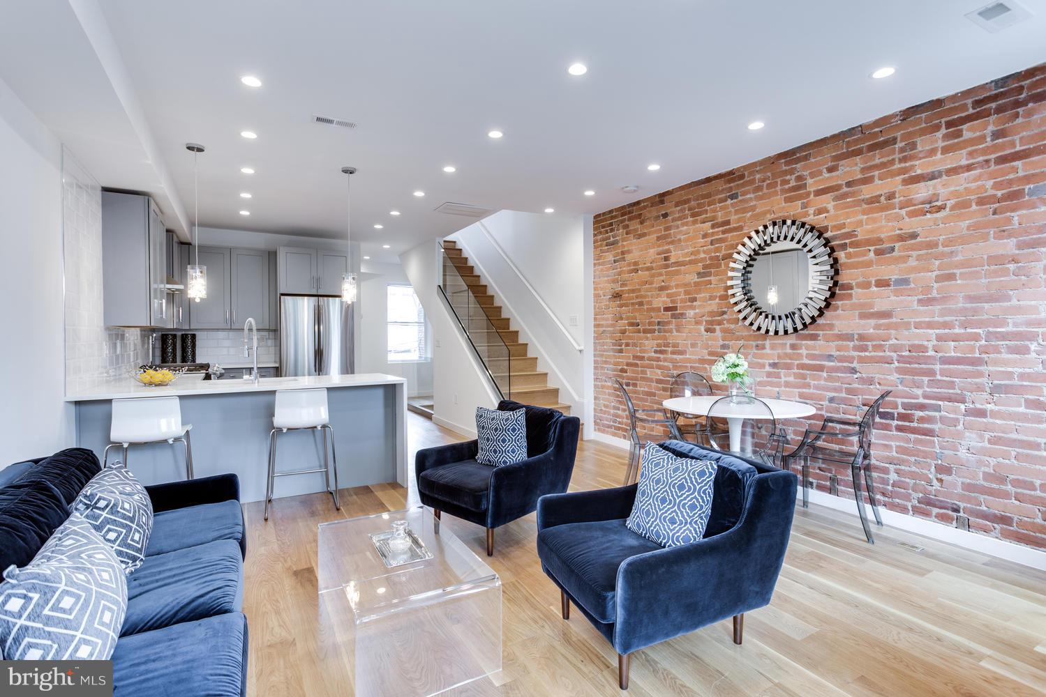 59 Randolph Place Northwest, Unit PH Washington, DC 20001 - Photo 11 of 27 a living room with couches coffee table and kitchen view with wooden floor