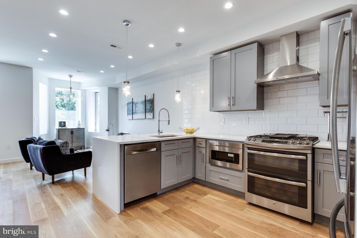 59 Randolph Place Northwest, Unit PH Washington, DC 20001 - Photo 3 of 27 a kitchen with stainless steel appliances granite countertop a stove a sink and a refrigerator