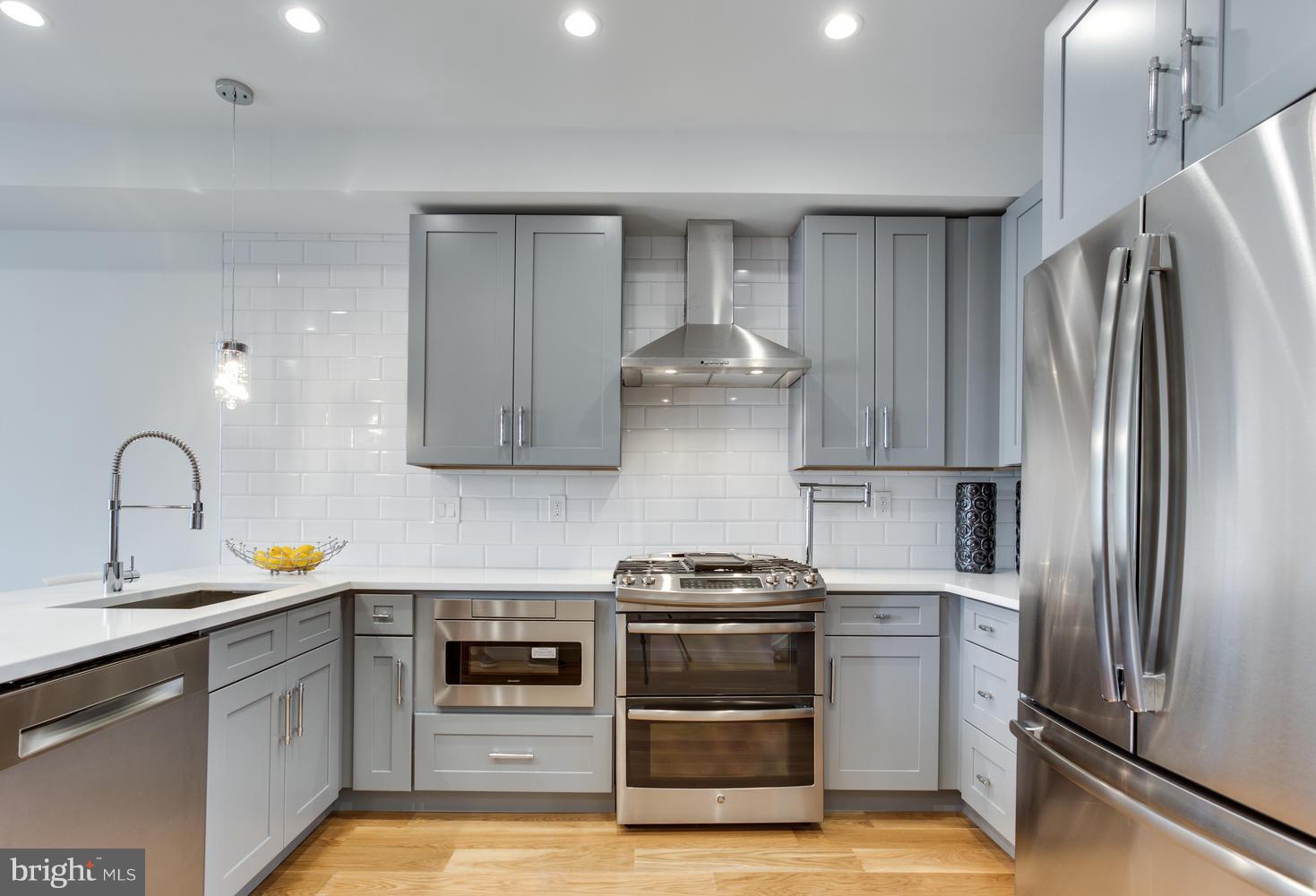 59 Randolph Place Northwest, Unit PH Washington, DC 20001 - Photo 4 of 27 a kitchen with white cabinets and stainless steel appliances
