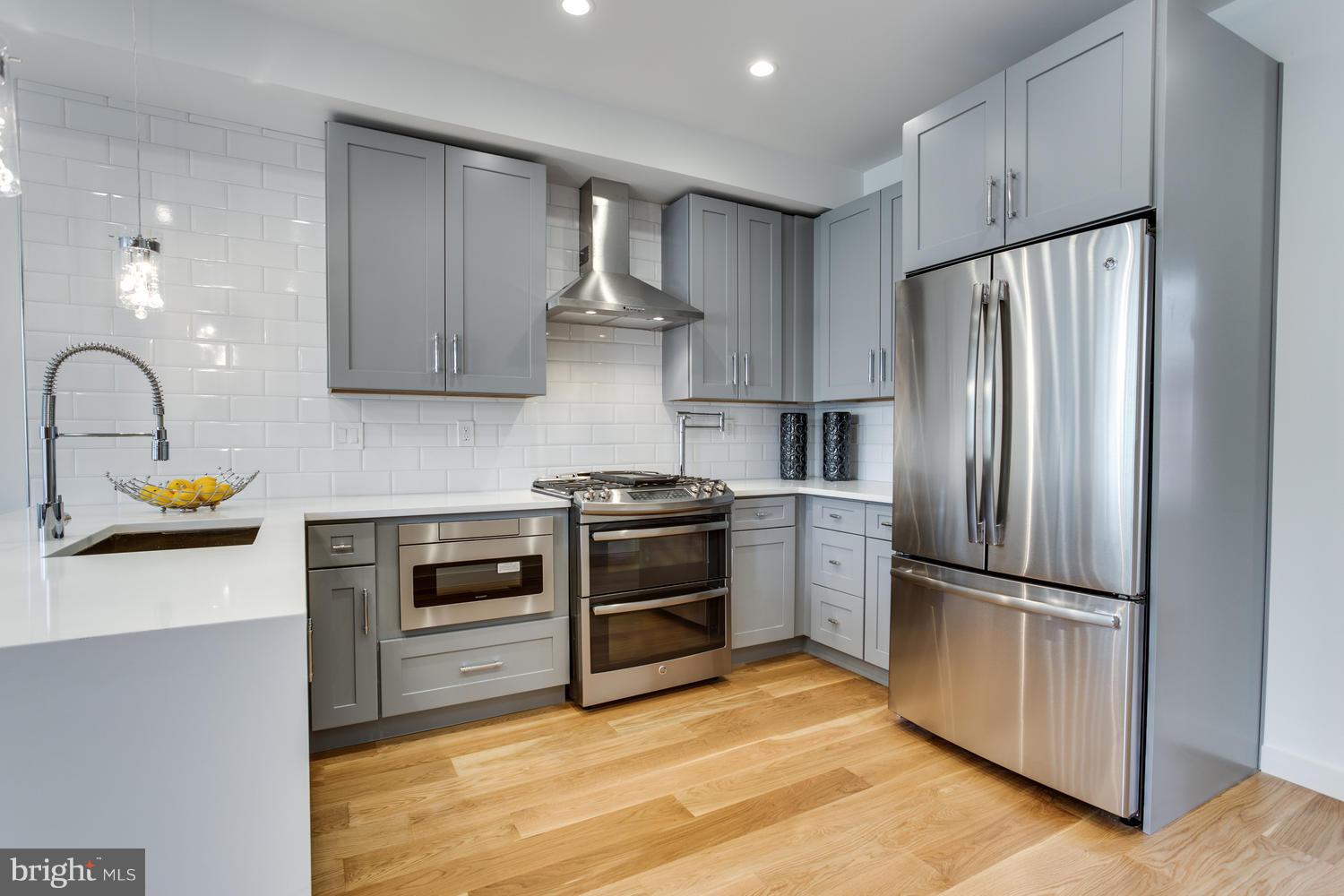 59 Randolph Place Northwest, Unit PH Washington, DC 20001 - Photo 5 of 27 a kitchen with stainless steel appliances and wooden cabinets
