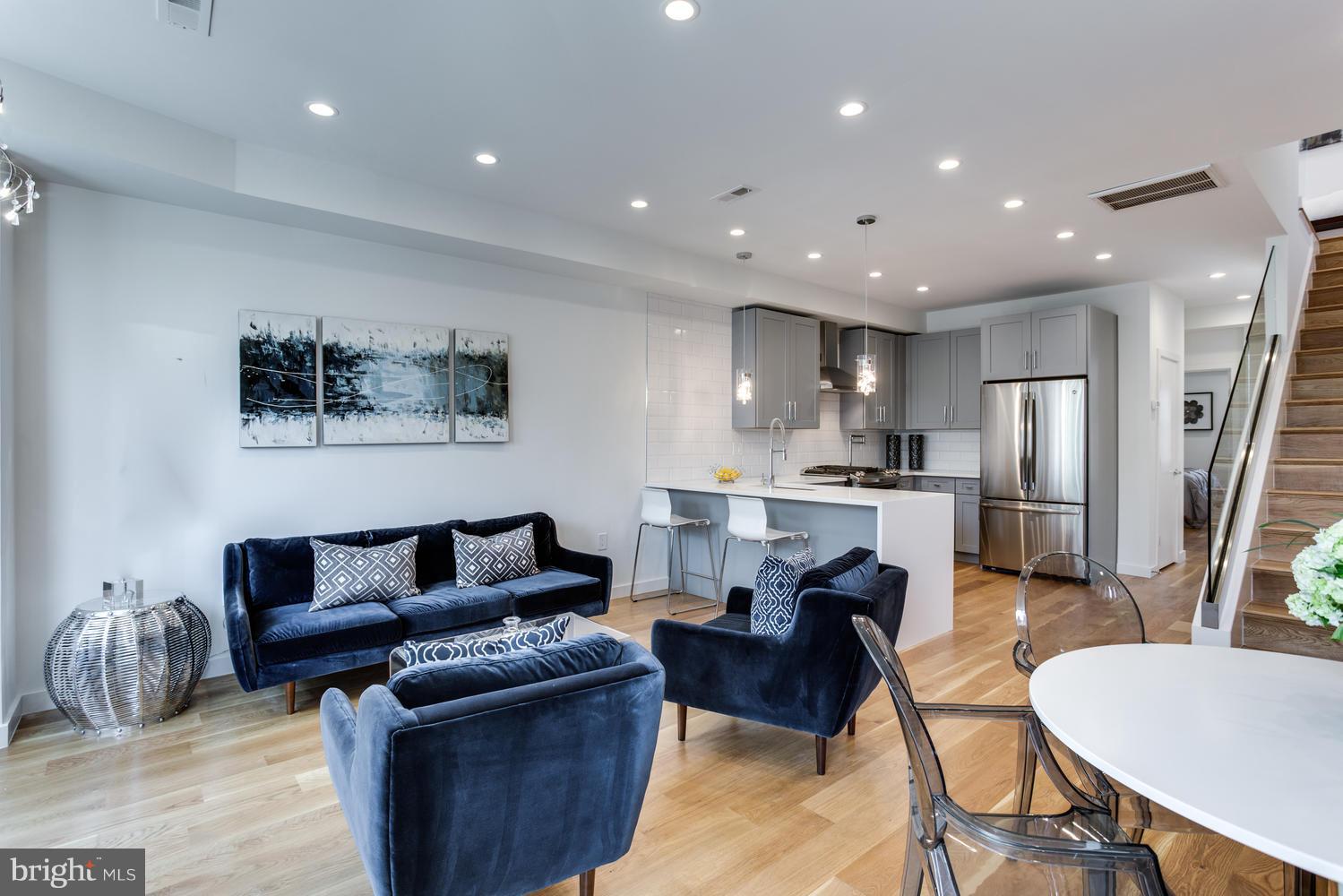 59 Randolph Place Northwest, Unit PH Washington, DC 20001 - Photo 9 of 27 a living room with furniture and a dining table with kitchen view