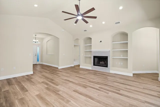 an empty room with wooden floor and a hallway