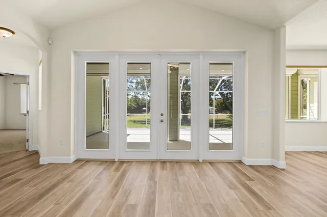 an empty room with windows and fan
