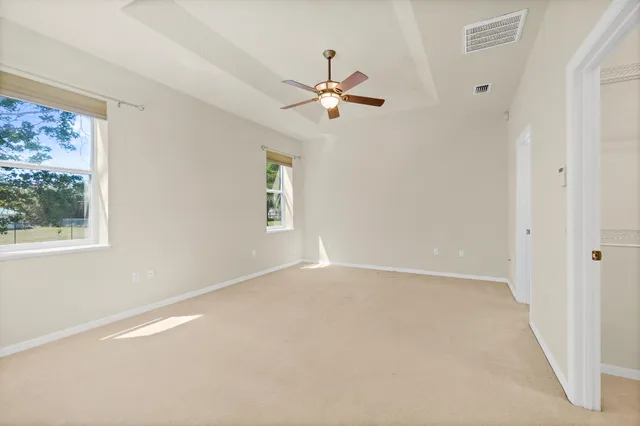 a view of an empty room and chandelier fan