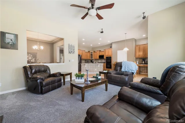 a living room with furniture and a view of kitchen