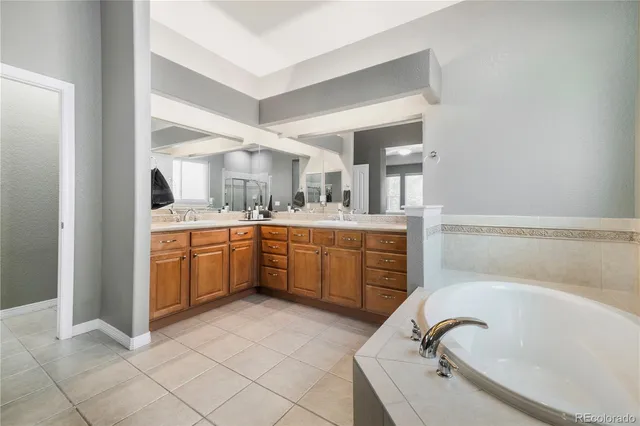 a bathroom with a tub sink and mirror