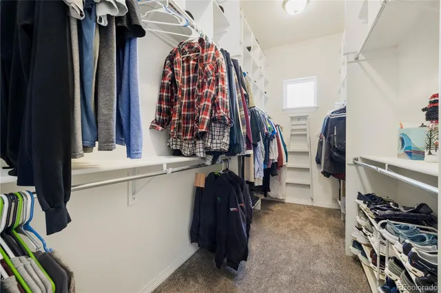 a view of walk in closet with clothes and shoes