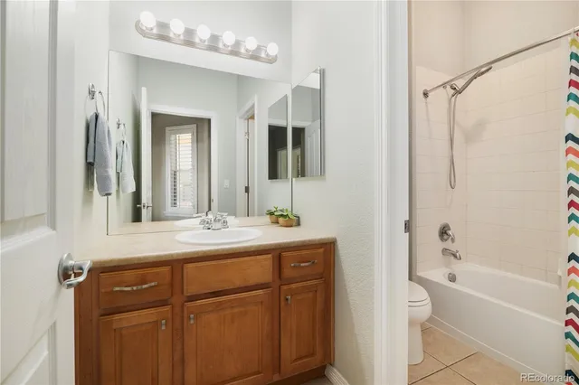 a bathroom with a granite countertop sink mirror and a bathtub