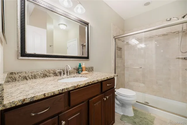 a bathroom with a granite countertop sink a toilet and a mirror