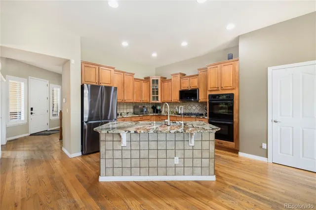 a kitchen with stainless steel appliances a stove top oven a refrigerator and cabinets