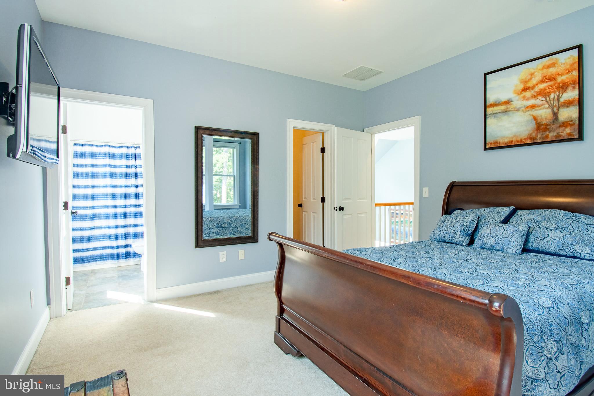 7841 Pea Neck Road St. Michaels, MD 21663 - Photo 27 of 41 a bedroom with a bed and a flat screen tv
