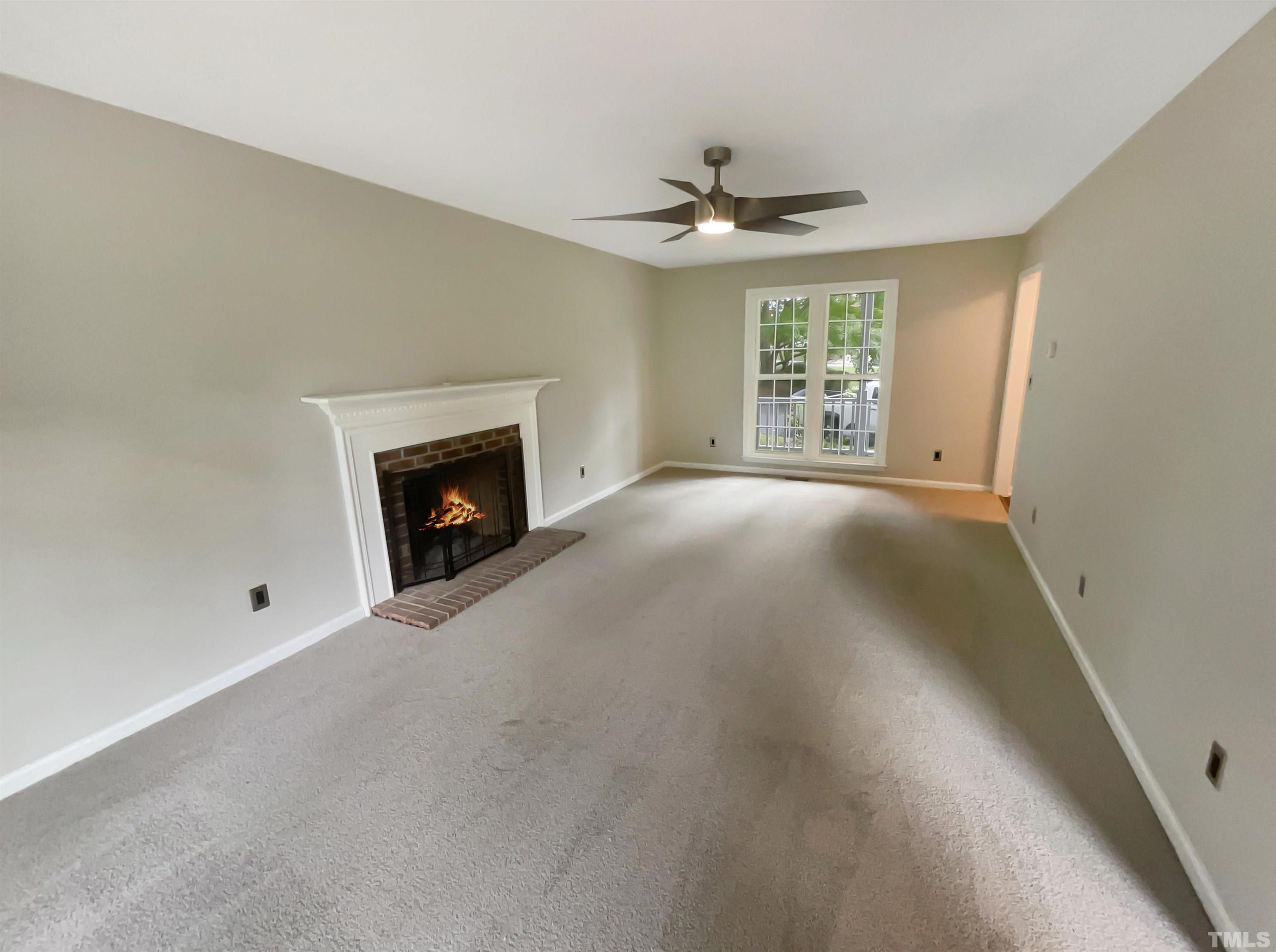 4521 Draper Road Raleigh, NC 27616 - Photo 5 of 17 a view of an empty room with a fireplace and a window