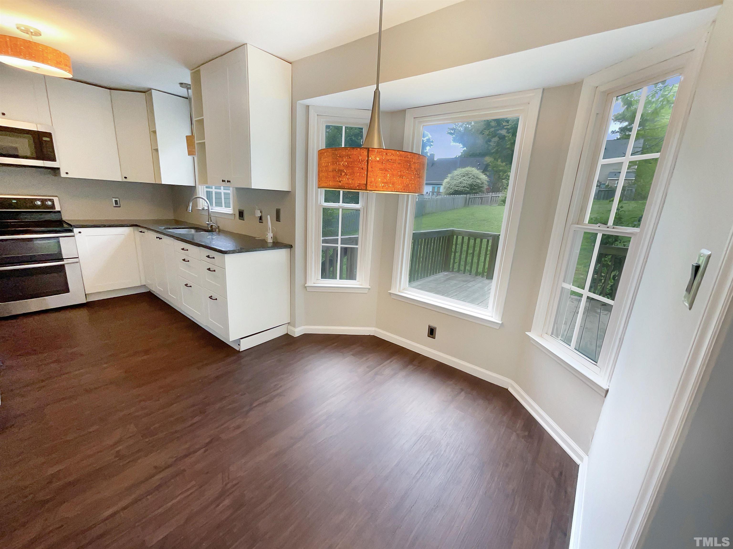 4521 Draper Road Raleigh, NC 27616 - Photo 9 of 17 a kitchen with wooden floors wooden cabinets and a sink