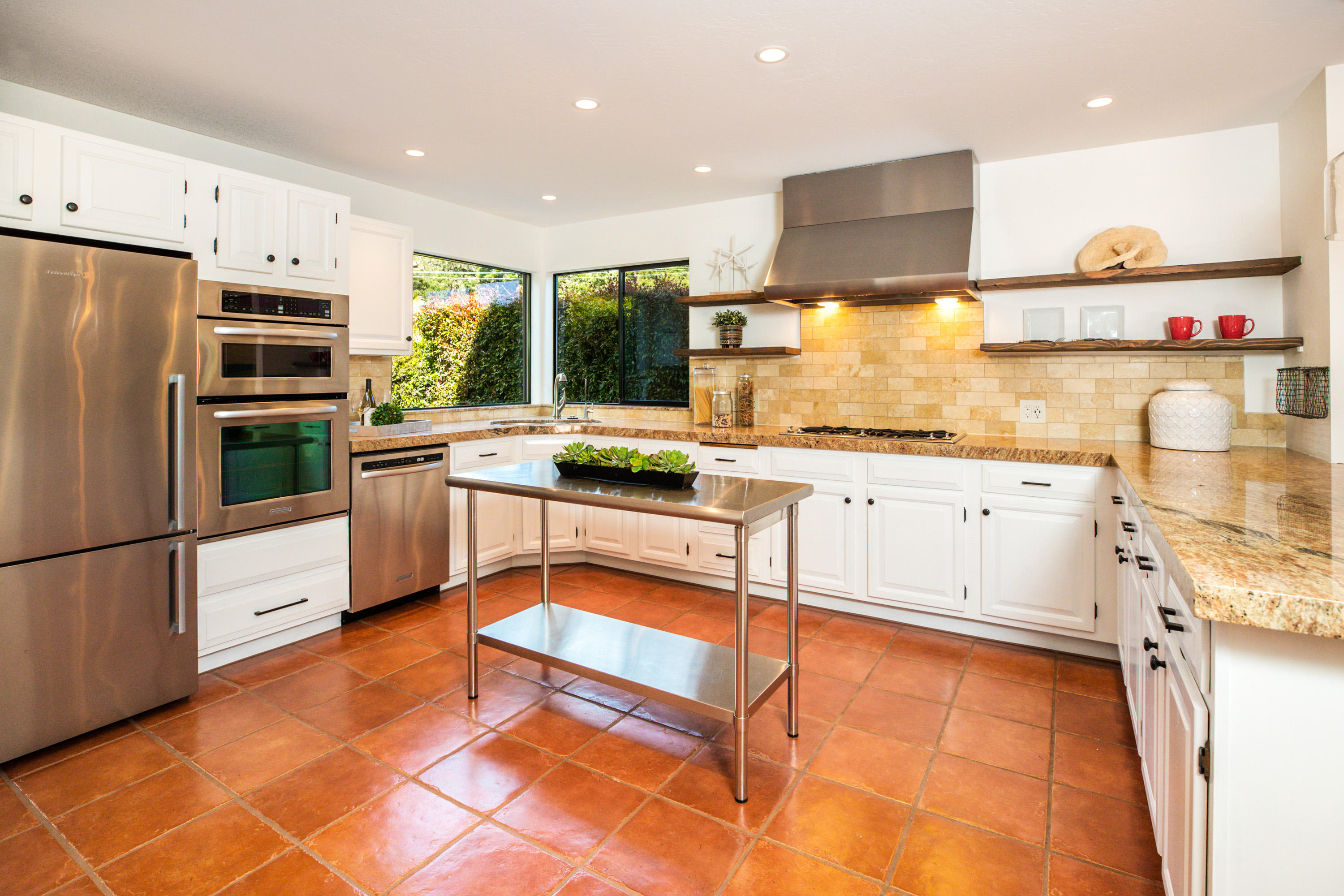 907 Fellowship Road Santa Barbara, CA 93109 - Photo 5 of 21 a kitchen with stainless steel appliances granite countertop a refrigerator a sink dishwasher a stove and white cabinets with wooden floor