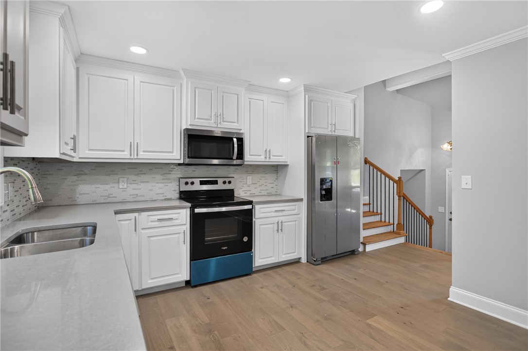 712 Beech Drive Seneca, SC 29678 - Photo 15 of 41 A contemporary kitchen showcasing gleaming stainless steel appliances and abundant white cabinetry.