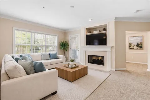 a living room with furniture a flat screen tv and a fireplace