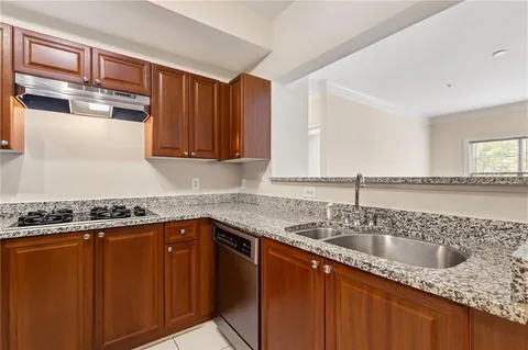 a kitchen with stainless steel appliances granite countertop a refrigerator and a stove top oven