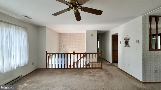 a view of a hallway with a chandelier fan and windows