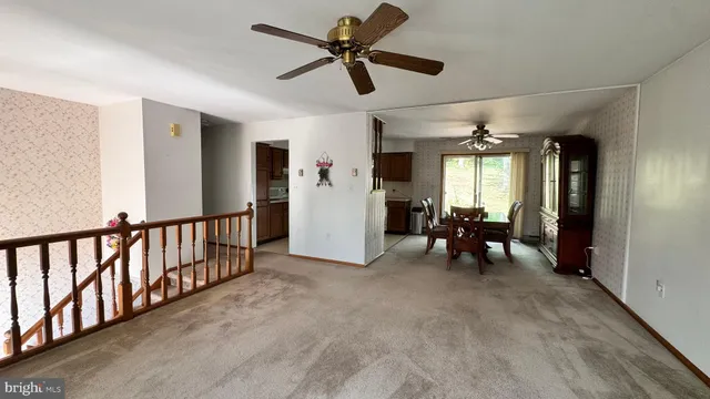 a view of a livingroom with furniture and a ceiling fan