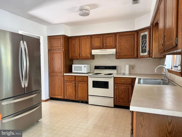 a kitchen with a sink stove top oven and cabinets