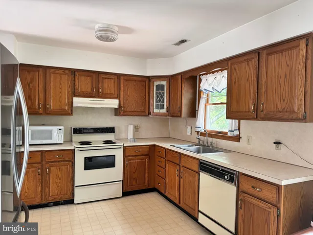 a kitchen with stainless steel appliances granite countertop a refrigerator stove and sink
